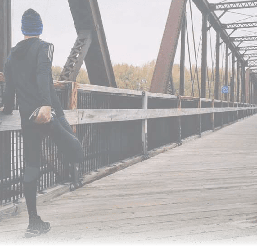 Man stretching on a bridge before running